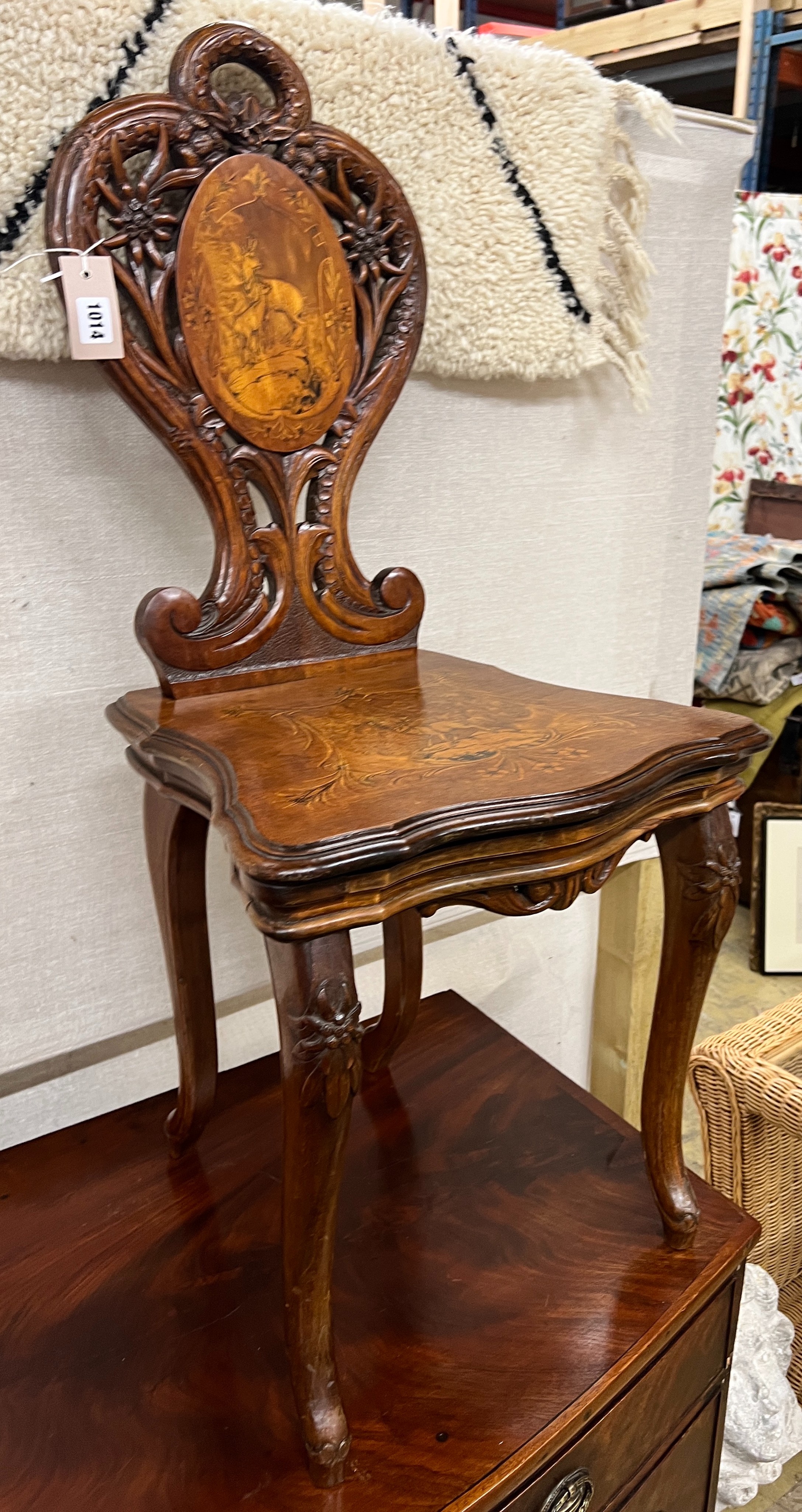 A 19th century Black Forest carved walnut musical chair decorated with panels of deer, width 45cm, depth 38cm, height 94cm